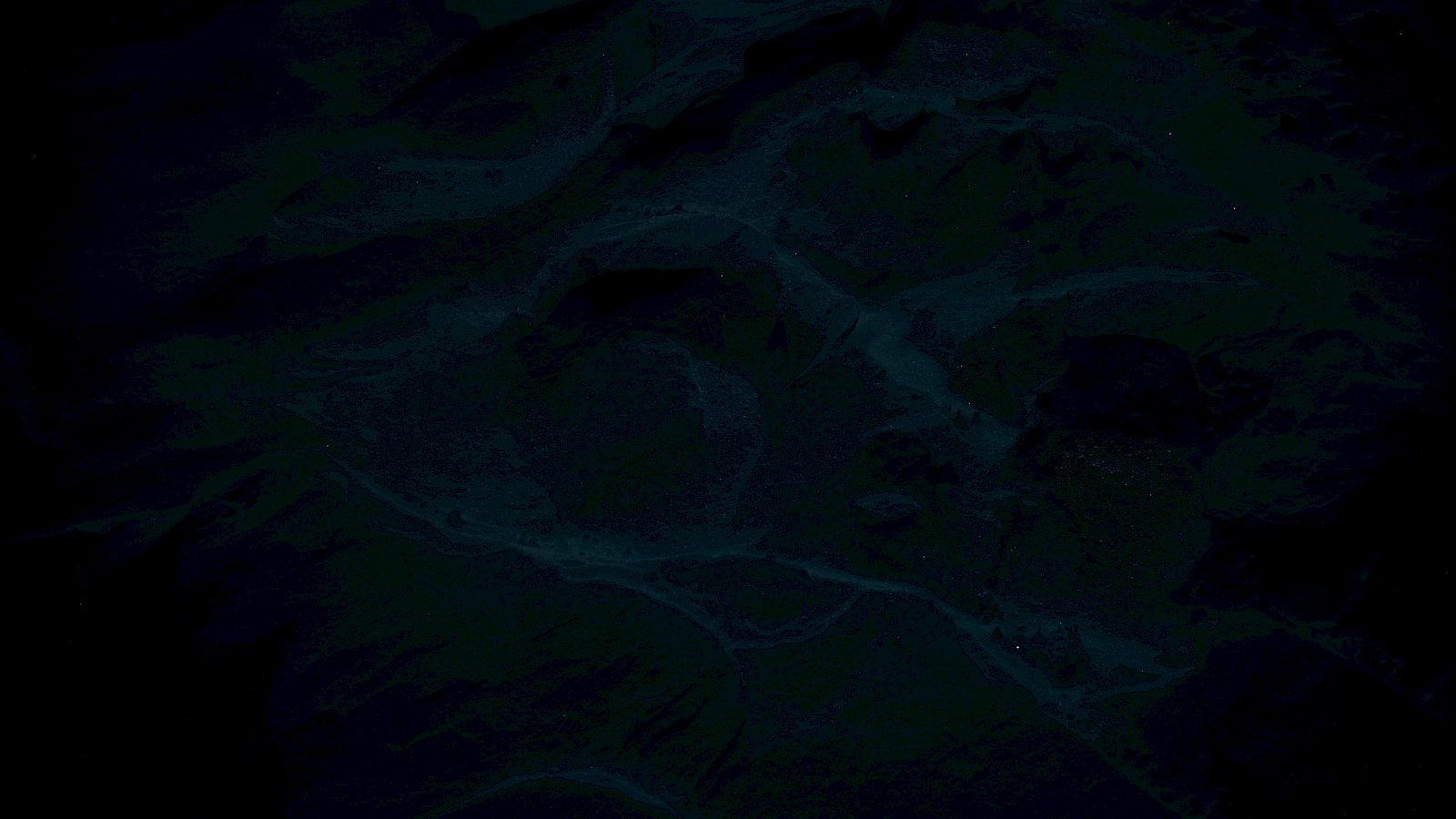 The image is too dark to discern any details or objects clearly; it seems to contain vague shapes or textures.